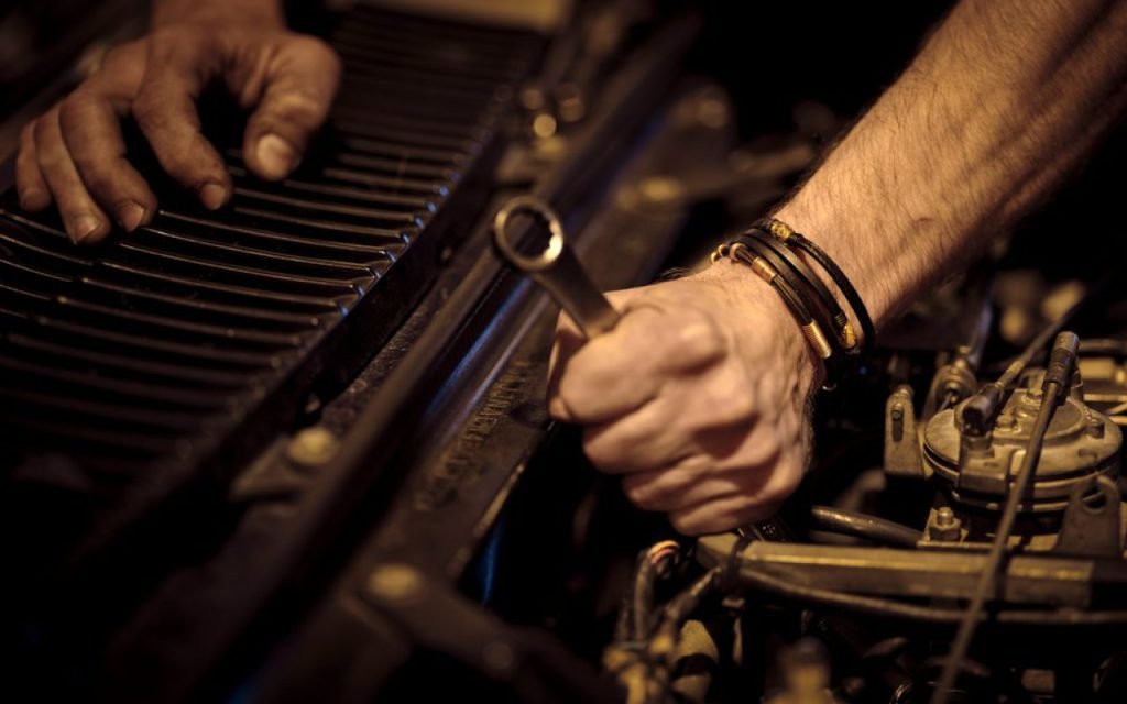 A mechanic checking a car engine under the hood
