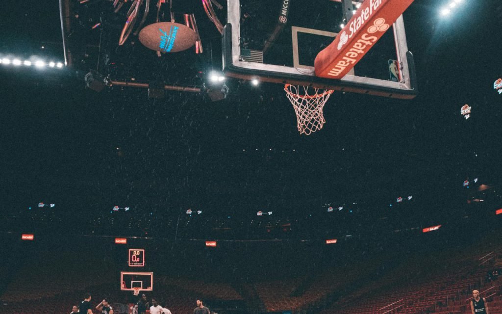 An empty indoor basketball court under arena lights