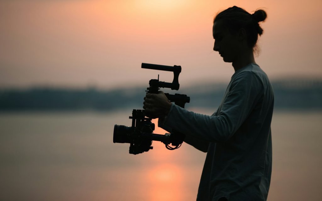 A camera operator filming with a handheld camera