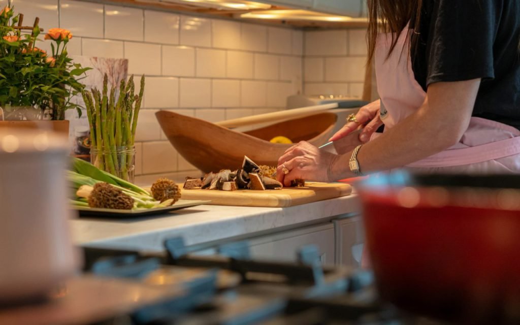A cook chopping onion on a cutting board