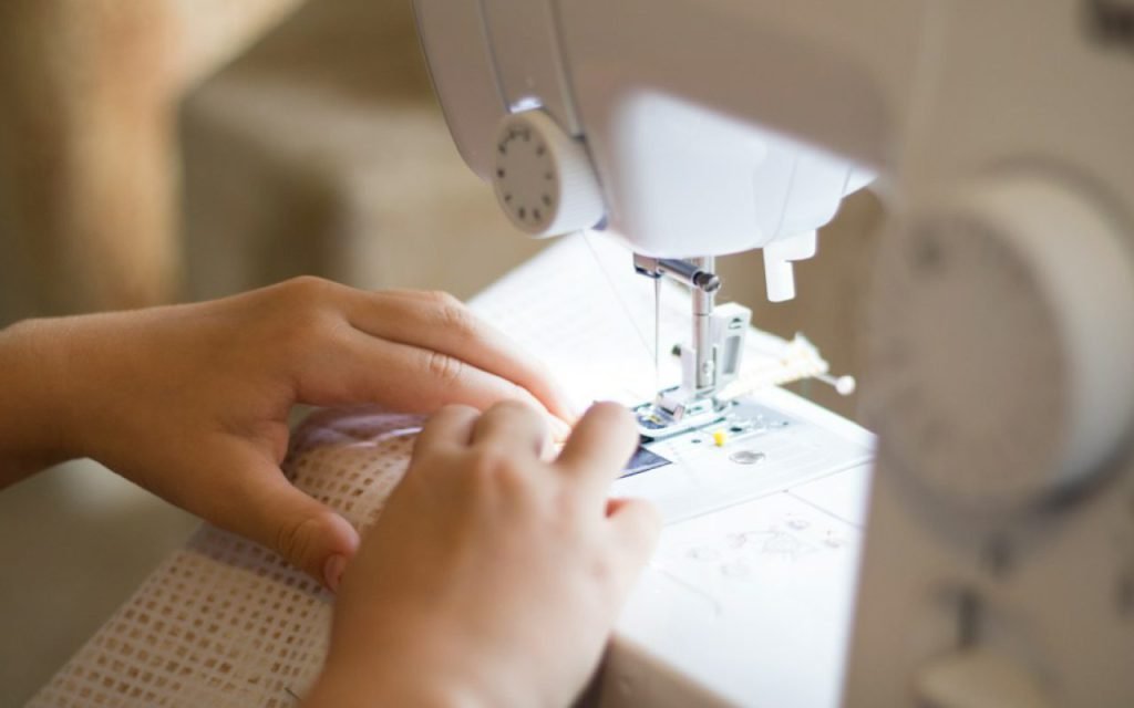A sewing machine on a worktable with fabric ready to stitch