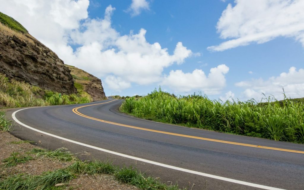 A quiet curving two-lane road with a wide shoulder