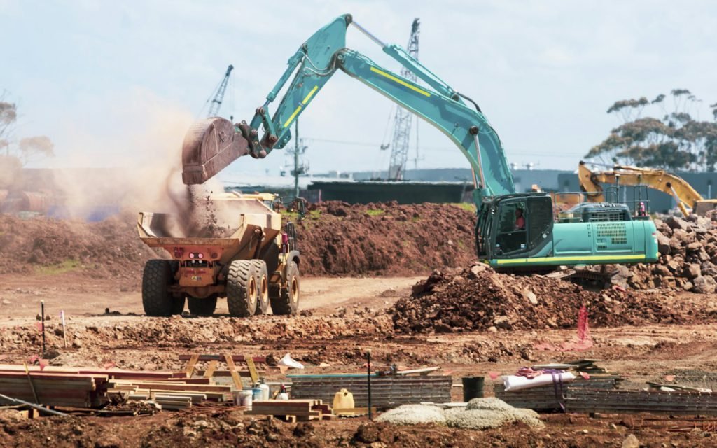 Excavator clearing debris at a work site
