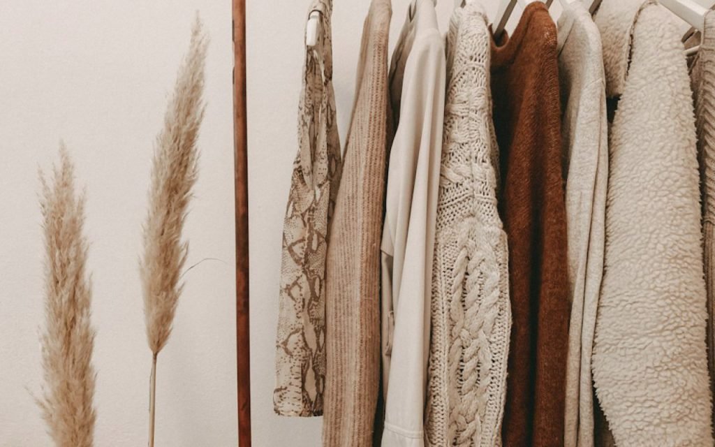 A freestanding clothing rack with neatly spaced garments