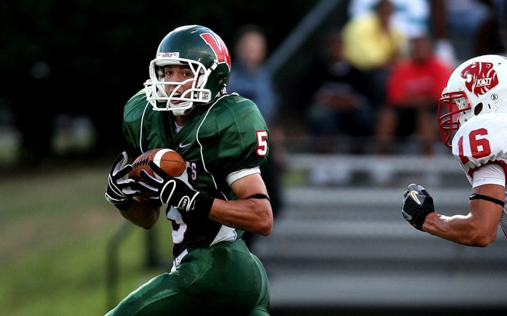 A high school football player in uniform on the field