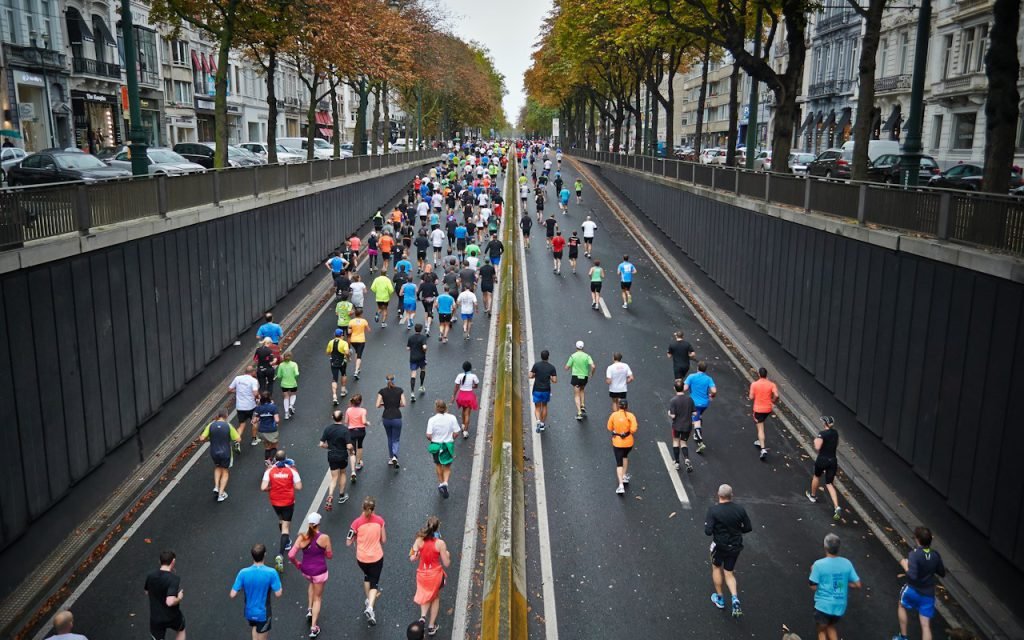 A large group of runners moving along a city street during a race