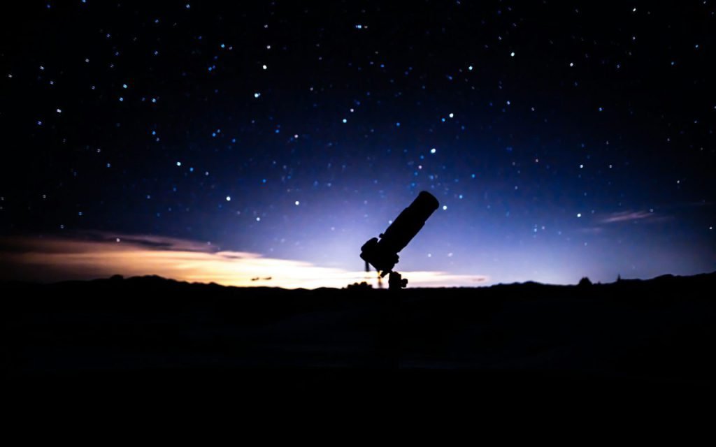 A telescope set up on a hill at dusk