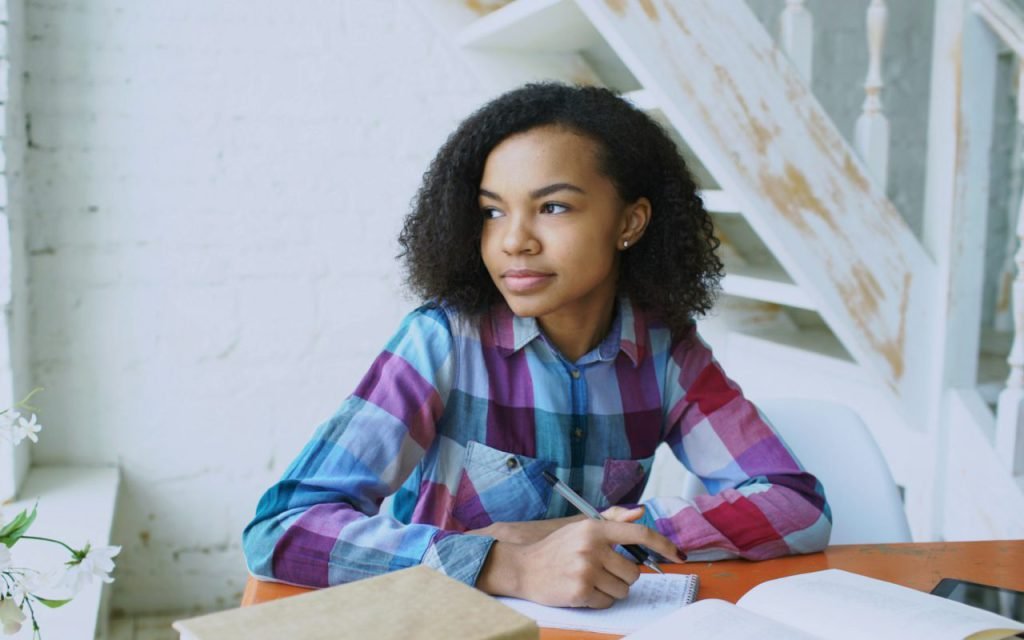 A teenager writing notes while studying